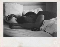 a black and white photo of a woman laying in bed with her head on the pillow