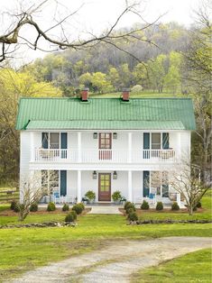 a large white house with a green roof