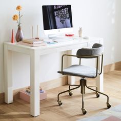 a white desk with a computer on top of it and a chair next to it