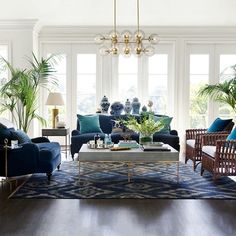 a living room filled with lots of furniture and plants on top of the couches