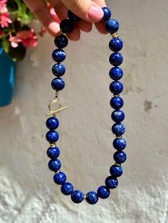 This classic statement necklace was made of huge (14 mm) natural lapis lazuli beads of the top quality. Striking blue color looks very refined and elegant and is complimented with modern gold details.   * Necklace length is 47 cm (18,5 inches) - please contact me if you need any adjustments.   * All metal parts are gold vermeil - silver with a thick layer of gold.    * Necklace comes in a gift box. It will be a great gift idea for a woman on any occasion.   * Handmade in Spain, shipment worldwid Blue Lapis Lazuli Necklace With Large Beads, Blue Lapis Lazuli Jewelry With Large Beads, Lapis Lazuli Beaded Necklaces With Large Beads As Gift, Lapis Lazuli Beaded Necklace With Large Beads For Gift, Royal Blue Lapis Lazuli Necklaces With Round Beads, Royal Blue Lapis Lazuli Necklace With Round Beads, Single Strand Lapis Lazuli Necklace, Royal Blue Round Beads Necklace For Gift, Lapis Lazuli Necklaces With 8mm Beads