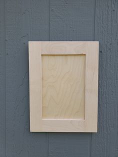 a wooden frame mounted to the side of a wall with a blue painted wood background