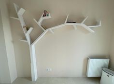 a white tree shelf with books on it