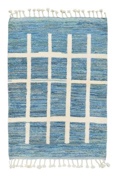 a blue rug with white squares and fringes on the bottom, against a white background