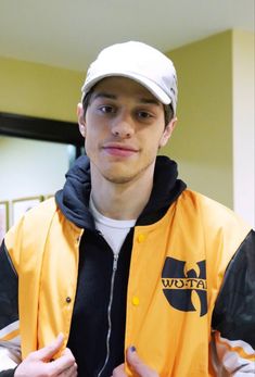 a young man wearing a yellow jacket and white hat