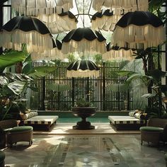 an indoor sitting area with umbrellas hanging from the ceiling and chairs on either side