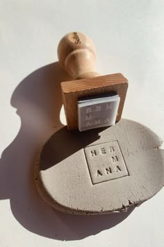 a rubber stamp with the word hemama on it and a wooden mallet next to it