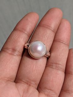 Pearl 925 Sterling Silver Handmade Ring PRODUCT DETAILS:- Material: 925 Sterling Silver Size in US: 8 3/4 & 9 1/4 Size in (UK/AU): R & S Weight: 7.9 Grams (Approximate) GEMSTONE DETAILS:- Name: Pearl Color: White Size: 12x12 MM Shape: Round Cut: Cabochon The silver ring in the photo is the one that you will be purchasing. Genuine sterling silver and Pearl Gemstone. This is a simple and elegant piece of Handmade jewelry at a very affordable price! And this ring will be shipped in an elegant gift White Dome Ring Fine Jewelry, Classic Round Rings With Pearl Drop, Sterling Silver Dome Wedding Ring, Round Sterling Silver Dome Wedding Ring, Pearl Stackable Round Rings For Anniversary, White Round Dome Ring For Anniversary, Minimalist White Dome Ring, Sterling Silver Open Pearl Ring Fine Jewelry, Sterling Silver Open Pearl Ring