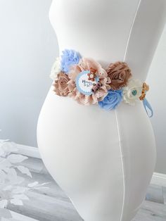 a white mannequin with blue and pink flowers on it's waist,