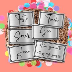 four metal name tags in a basket with confetti