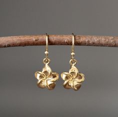 "Sweet and delicate 24k gold vermeil Plumeria flower charms dangle from 18k gold vermeil earwires. The perfect go-to-earrings for any occasion. Gold flower charms: 11x11mm Total length of earrings: 1\" All gold is gold vermeil. These earrings are also available in a larger size in silver... www.etsy.com/listing/693341987/silver-flower-earrings As the owner, maker, designer, and curator of this shop, I take great pride in providing you with jewelry that you will love to wear everyday, for special Gold Floral Earrings, Cute Earrings Aesthetic Gold, Gold Earrings With Flower Charm And Pendant, Yellow Gold Flower Charm Earrings, Yellow Gold Flower Earrings With Charm, Yellow Gold Flower Jewelry With Matching Earrings, Brass Drop Earrings With Flower Charm, Gold Teardrop Flower Charm Earrings, Gold Brass Earrings With Flower Charm