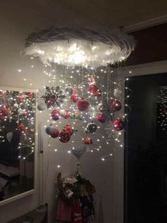 a christmas decoration hanging from the ceiling in a room with lights and ornaments on it