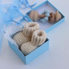 two knitted baby booties in a blue box