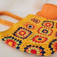 a crocheted bag with an orange hat on top and a white tablecloth