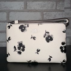 Printed Coated Canvas And Smooth Leather Two Credit Card Slots Zip-Top Closure, Fabric Lining Wrist Strap Attached 6 1/4" (L) X 4" (H) X 1/2" (W) Elegant Spring Wristlet For Everyday, Elegant Rectangular Wristlet For Spring, Elegant Rectangular Spring Wristlet, Elegant Spring Rectangular Wristlet, White Coach Wallet Pouch, Coach White Pouch Wallet, White Rectangular Clutch For Spring, Elegant Spring Wristlet For Daily Use, Trendy White Clutch