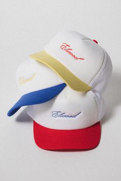 You can never have too many. The Script Trucker Cap has a high crown design with a snapback closure. The front features our Elwood logo in cursive. Available in Red/White, Yellow/White, and Blue/White. 70 DENIER INTERLOCK, 3 OZ FOAM FRONT WITH ELWOOD EMBROIDERY MESH TOP PLASTIC SNAP STRIP ADJUSTER White Retro Snapback Hat With Curved Brim, Yellow 5-panel Trucker Hat For Streetwear, White 5-panel Snapback Hat With Letter Print, Yellow Snapback Hat With Curved Brim For Streetwear, White Retro Baseball Cap For Streetwear, Retro White Snapback Baseball Cap, Yellow Snapback Hat For Streetwear, Yellow Snapback Baseball Cap With Letter Print, Yellow Trucker Hat With Flat Brim For Streetwear