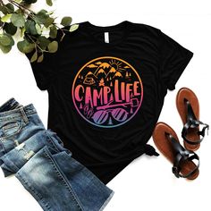 a t - shirt with the words camp life on it next to jeans and sandals