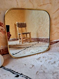 a chair is reflected in a mirror on the floor