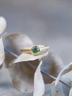 The round bicolor green sapphire was mined in the Songea, Tanzania, and hasn't been heated or treated. The 18 karat yellow gold band brings out the sapphire's warmer tones and magnifies its gorgeous gleams. Each piece of our jewelry is handcrafted with love. Gold Sapphire Ring With Smooth Bezel, Green Sapphire Round Ring, Fine Jewelry 14k Gold Green Sapphire Ring, Green Sapphire Round Cut Ring, Everyday Yellow Gold Solitaire Emerald Ring, Timeless Round Gold Emerald Ring, Gold Yellow Sapphire Round Ring, Gold Round Yellow Sapphire Ring, Gold Yellow Sapphire Ring, Round