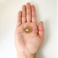 The listing is for a Vintage Seed Pearl Brooch. The brooch features a prong set mother of pearl flat cabochon with beautiful open work swirling gold frame. The decoratively engraved gold frame is accented with 8 small seed pearls set around the center mother of pearl flat cabochon. Measurement: 0.879 inches long x 0.982 inches wide. Weight: 3.4 grams Markings: unmarked but tests as 10K. Condition: Excellent condition. Has a working C-clasp closure. ❤All items in my shop are Estate, Vintage, and Formal Gold Gemstone Brooches, Antique Gold Brooch With Gemstone, Antique Gold Gemstone Brooch, Elegant Gold Filigree Brooches, Elegant Gold Brooches With Gemstones, Elegant Yellow Gold Enamel Pin Gift, Elegant Gold Gemstone Brooches, Luxury Gold Enamel Pin As Gift, Luxury Gold Enamel Pin Gift