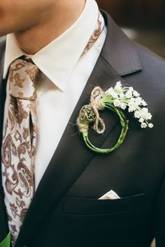 a man wearing a suit and tie with a boutonniere on his lapel