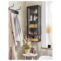 a bathroom with towels hanging on the wall and a shelf next to it that is filled with various items