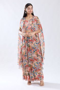 Peach asymmetric cape with floral abstract pattern. Paired with a crop top and sharara. - Aza Fashions Summer Festive Palazzo Set With Cape Sleeves, Summer Georgette Sets With Cape Sleeves, Summer Sets In Georgette With Cape Sleeves, Summer Sets With Cape Sleeves In Georgette, Summer Sets With Sheer Dupatta And Cape Sleeves, Summer Georgette Sets With Sheer Dupatta, Summer Sets With Sheer Dupatta In Georgette, Floral Print Chiffon Sets, Summer Party Palazzo Set With Cape Sleeves