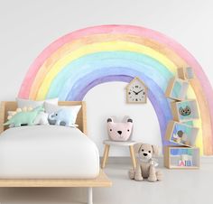 a child's bedroom with a rainbow painted on the wall and toys in front