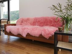 a couch with pink fur on it in a living room