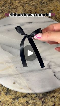 someone is holding a black ribbon on top of a marble platter with the words ribbon bowstutorial