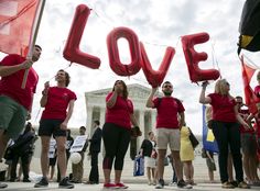 people standing in front of the u s supreme building holding up letters that spell out love