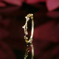 a close up view of a gold ring with white flowers on it's side