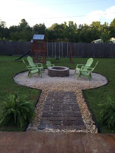 an outdoor fire pit surrounded by lawn chairs and graveled path leading to the back yard