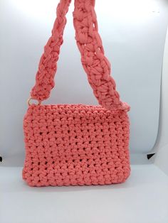 a pink crocheted purse sitting on top of a white table