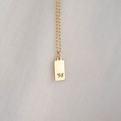 "Personalized Gold Rectangle Pendant Necklace from our Memoirs Made Collection. Personalize a short word or up to three initials on the lovely 14k gold filled tag necklace Free Engraving for a limited time! NECKLACE DETAILS ⚬ 14k gold-filled rectangle and chain. ⚬ Chain in your choice of 16\", 18\", or 20\" length ⚬ Rectangle measures 13.5mm x 6mm (.53\" x .23\"). ⚬ Spring ring clasp closure. ⚬ Personalized engraving of 1-3 characters (including spaces); ⚬ Choice of 3 fonts for the engraving. ⚬ Classic Gold Name Necklace For Everyday, Simple Engraved Gold Charm Necklace, Simple Gold Engraved Charm Necklace, Simple Gold Charm Necklaces For Anniversary, Simple Gold Charm Necklace For Anniversary, Simple Gold Engraved Necklaces, Minimalist Tarnish Resistant Charm Necklaces For Anniversary, Simple Gold Engraved Necklace, Everyday Gold Nameplate Charm Necklaces