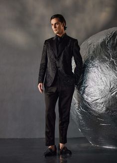 Editor's Note Featuring tone on tone embroidered dire black tux with kat dana details. Paired with a black pintuck shirt and black tapered trousers. Fabric: Linen silk Color: Black Components: Tuxedo, shirt and trousers Occasion: Evening wear Fit: Regular Note: Product colour may slightly vary due to photographic lighting sources Care: Dry clean only About the Designer After establishing himself as the leading couturier in the industry of menswear, Jatin Malik went on to explore luxury footwear. Black Silk Blazer With Suit Collar, Tailored Party Sets With Suit Collar, Fitted Designer Formal Sets, Designer Fitted Formal Sets, Tailored Silk Party Sets, Fitted Designer Sets For Formal Occasions, Designer Semi-formal Sets With Suit Collar, Designer Semi-formal Collared Sets, Tailored Black Silk Tuxedo