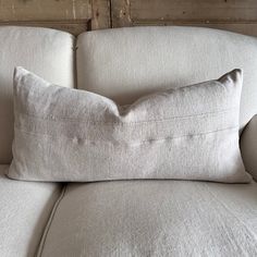 a white pillow sitting on top of a couch