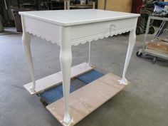 a white table sitting on top of a wooden shelf