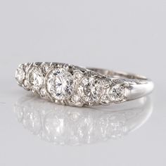 a five stone diamond ring on a reflective surface