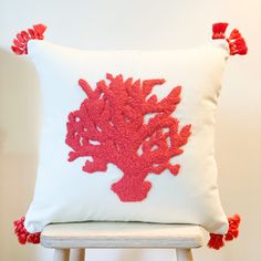 a red coral pillow on a white chair