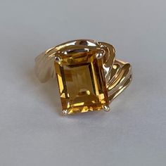 Vintage 14K Citrine Ring with Ribbed Bypass Band, Size 3.5, 4.2grams, November Birthstone  Weight: 4.2 grams Stones: Citrine Size Stone: ca. 10mm x 7.5mm Color Gemstone: Honey-Orange  Number of Gemstones: 1 Cut: Emerald Material: 14 Karat Yellow Gold Band Width: ca. 2mm at smallest point Marking: symbol, 14KP  Condition: Very good preowned with light usage throughout -refer to pictures for condition.  All jewelry will be professionally cleaned before shipping and come in a beautiful little gift box. Returns accepted but are subjected to a 8% restock fee. Returns are only accepted for national orders. Orange Number, November Birthstone Jewelry, Citrine Ring, November Birthstone, Fancy Jewelry, Gold Band, Birthstone Jewelry, Rings Statement, Gold Bands