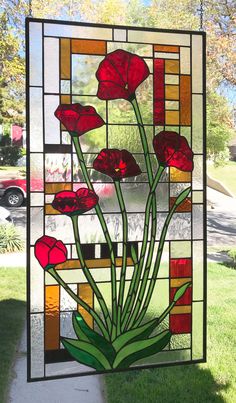 a stained glass window with red flowers in it