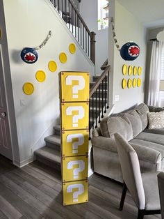 a yellow sign sitting in the middle of a living room next to a stair case