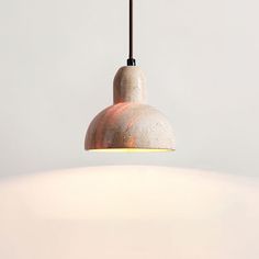 a light that is hanging from a ceiling in a room with white walls and flooring