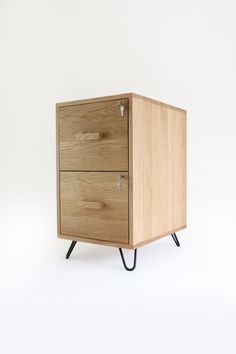 a wooden cabinet with two drawers and black hairpinks on the legs, against a white background