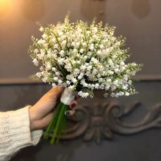 a woman holding a bouquet of white flowers