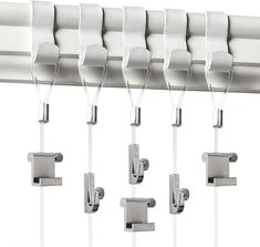 several white chairs are hanging from the ceiling in front of a row of metal brackets