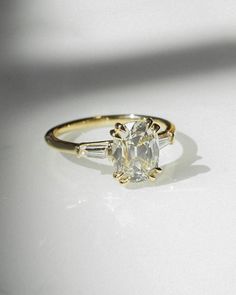 a yellow gold ring with an oval cut diamond