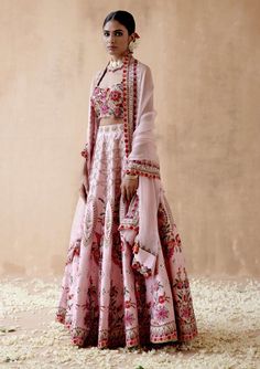 Editor's Note Presenting a graceful pink raw silk lehenga set adorned with intricate floral thread embroidery, elegantly highlighted with various embellishments. This captivating ensemble is paired with an embroidered blouse and dupatta, creating a charming and elegant look perfect for special occasions or festive celebrations. The soft pink shade, the delicate embroidery, and the ornate details on both the blouse and dupatta add a touch of sophistication, making this outfit a statement of timel Noodle Strap Blouse, Pink Raw Silk Lehenga, Floral Thread Embroidery, Raw Silk Lehenga, Pink Lehenga, Delicate Embroidery, Blouse Models, Pink Shade, Silk Lehenga