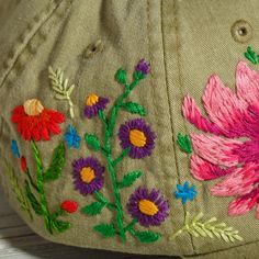 a baseball cap with embroidered flowers on it